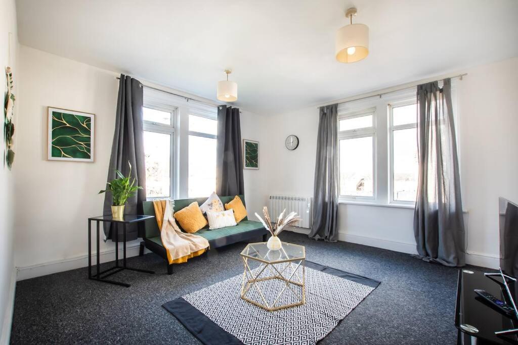 uma sala de estar com um sofá e algumas janelas em A cosy 2 bed flat in Swindon em Swindon