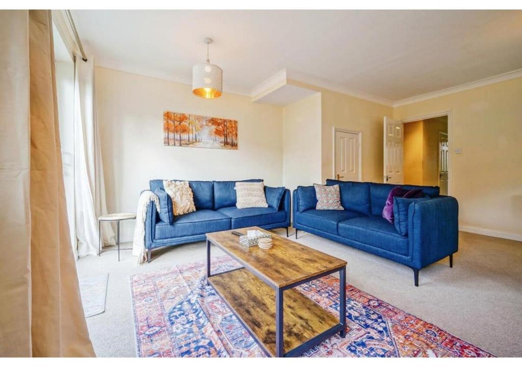 Sala de estar con sofás azules y mesa de centro en Charming Uxbridge 3BR Home with Parking en Uxbridge