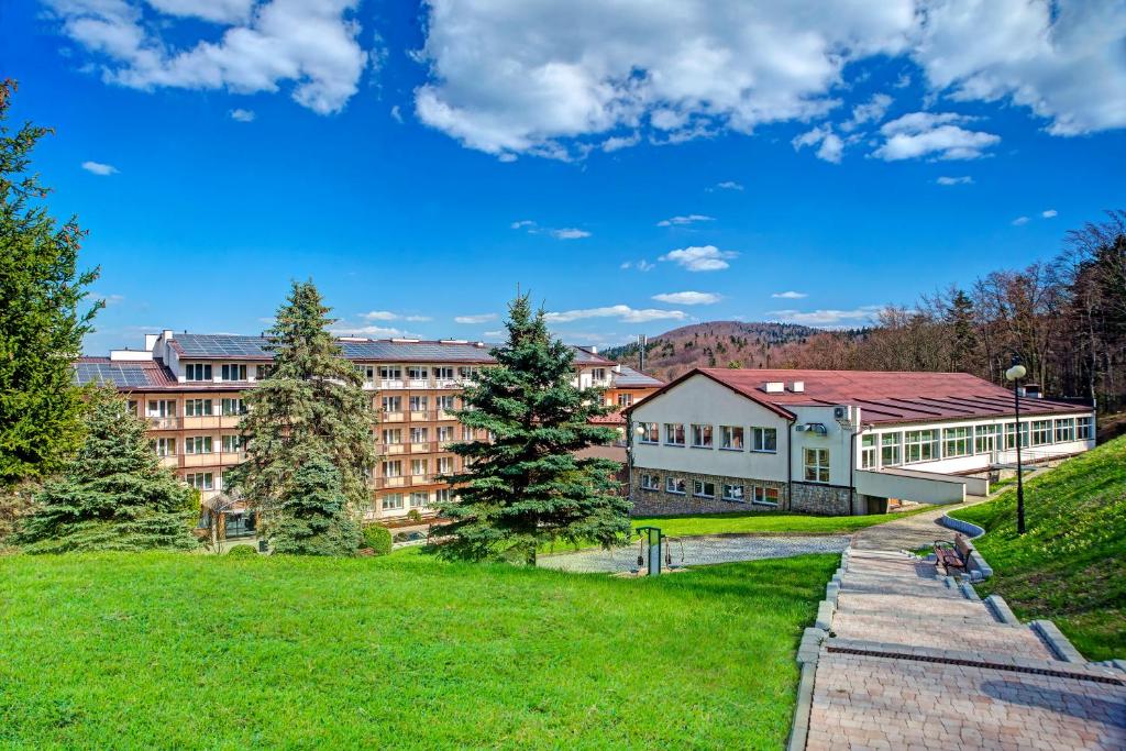 a university campus with a green lawn and buildings at Sanatorium GÓRNIK in Iwonicz-Zdrój