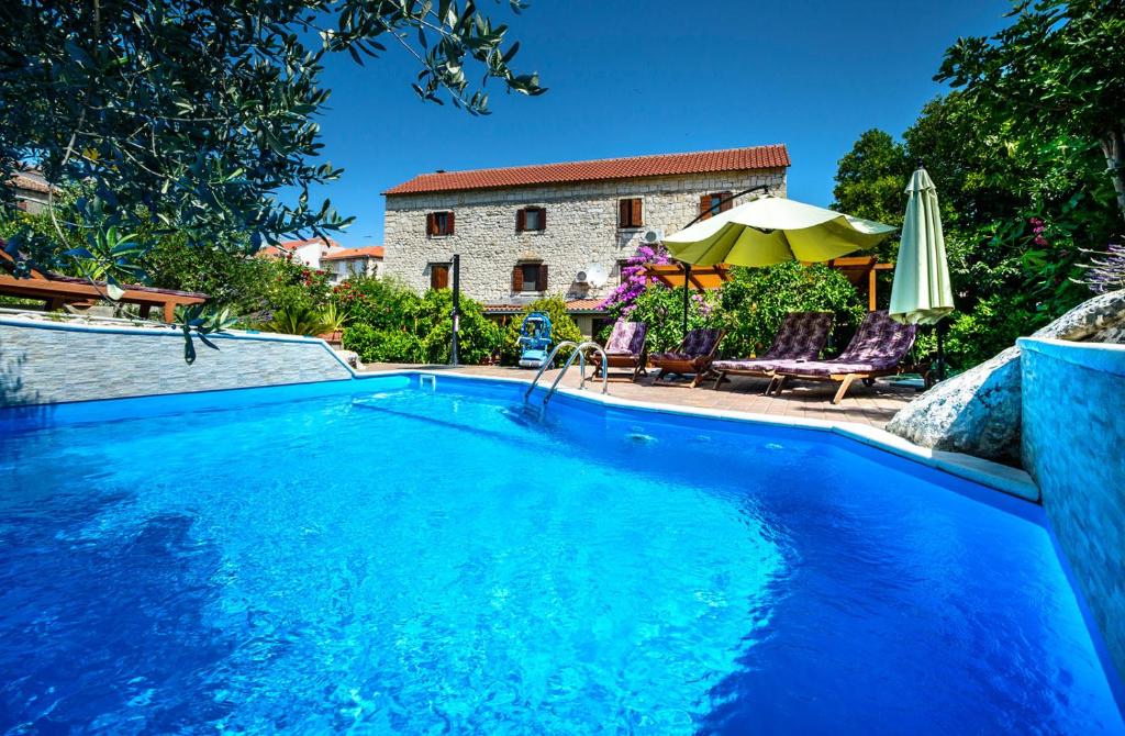 a swimming pool in front of a house at Vila Donna Apartments in Trogir