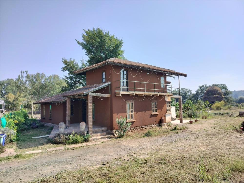 a small house in the middle of a field at Khirni House in Māndu