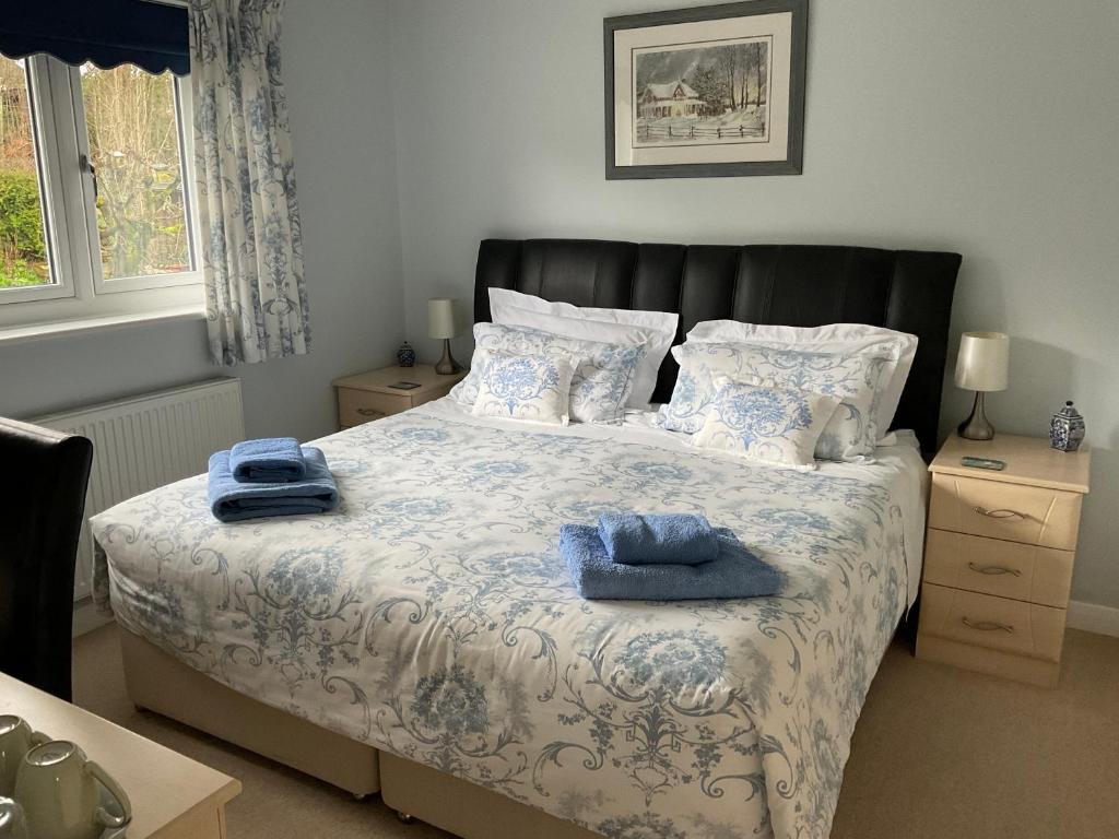 una camera da letto con un letto con asciugamani blu di Private room in bright detached house a Salisbury
