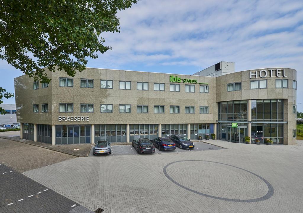 a hotel with cars parked in a parking lot at ibis Styles Almere in Almere