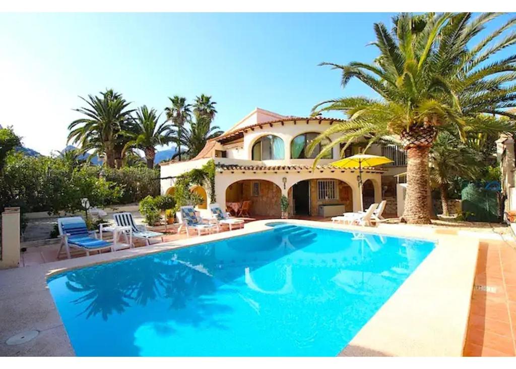 ein Haus mit einem großen Pool mit Palmen in der Unterkunft Valet in Calpe