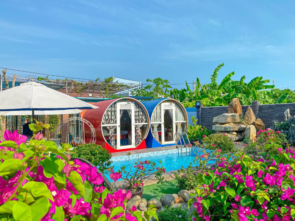une maison de jeux avec une piscine dans un jardin dans l'établissement Khoảnh Khăc Homestay, à Vung Tau