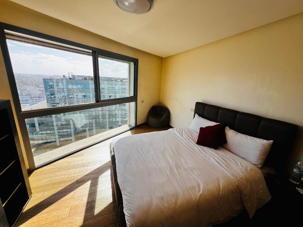 um quarto com uma cama e uma grande janela em Magnifique appartement pleine vue mer Marina Casablanca em Casablanca