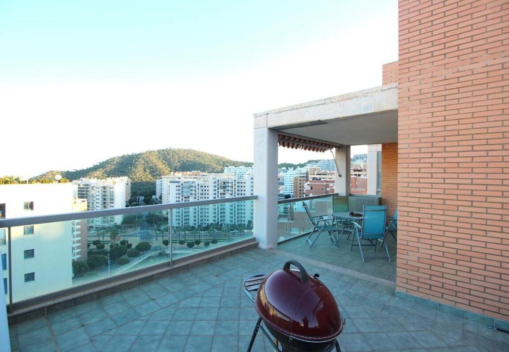 d'un balcon avec barbecue et vue sur la ville. dans l'établissement Mirador de la Isla, à La Cala de Finestra