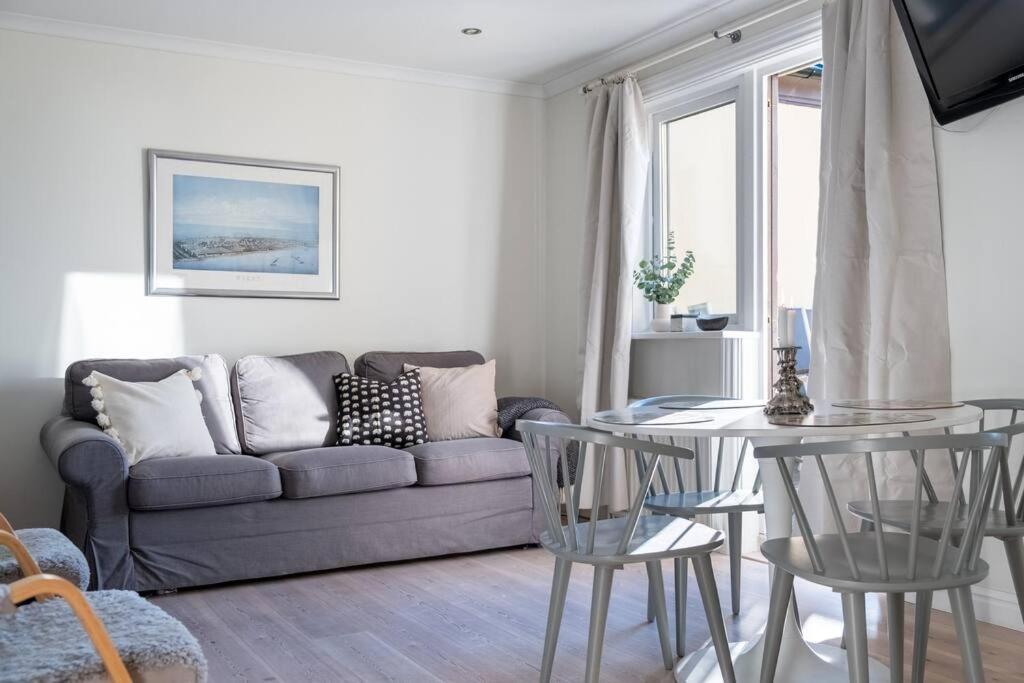 sala de estar con sofá, mesa y sillas en Lägenhet med vacker havsutsikt, en Visby