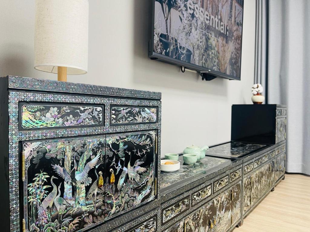 a large black cabinet with a painting on the wall at INN-The City MyeongDong in Seoul