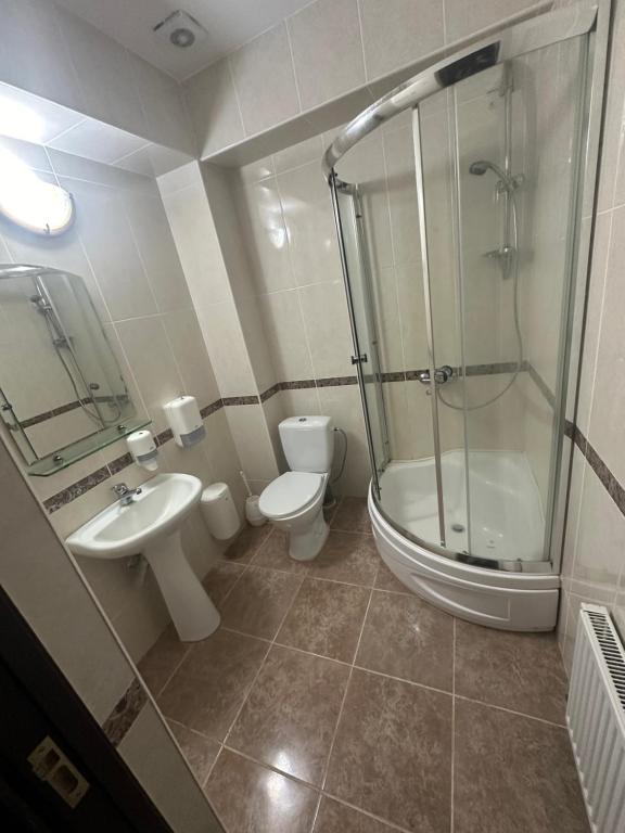 uma casa de banho com um chuveiro, um WC e um lavatório. em Hincesti Hotel em Hînceşti