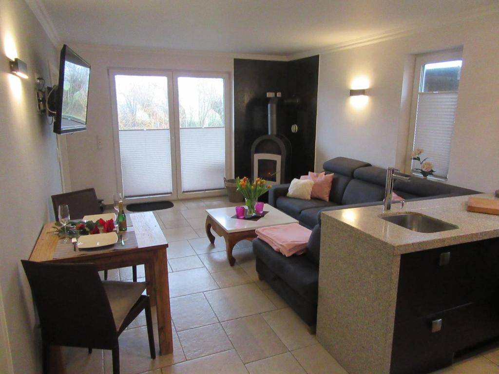 a kitchen and living room with a couch and a table at Ferienwohnung Strand EG in Fehmarn