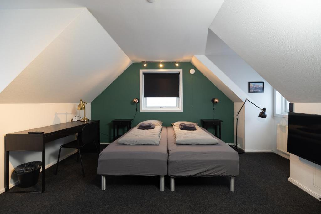 a room with two beds and a desk in a attic at Kulukis Downtown Hostel in Nuuk