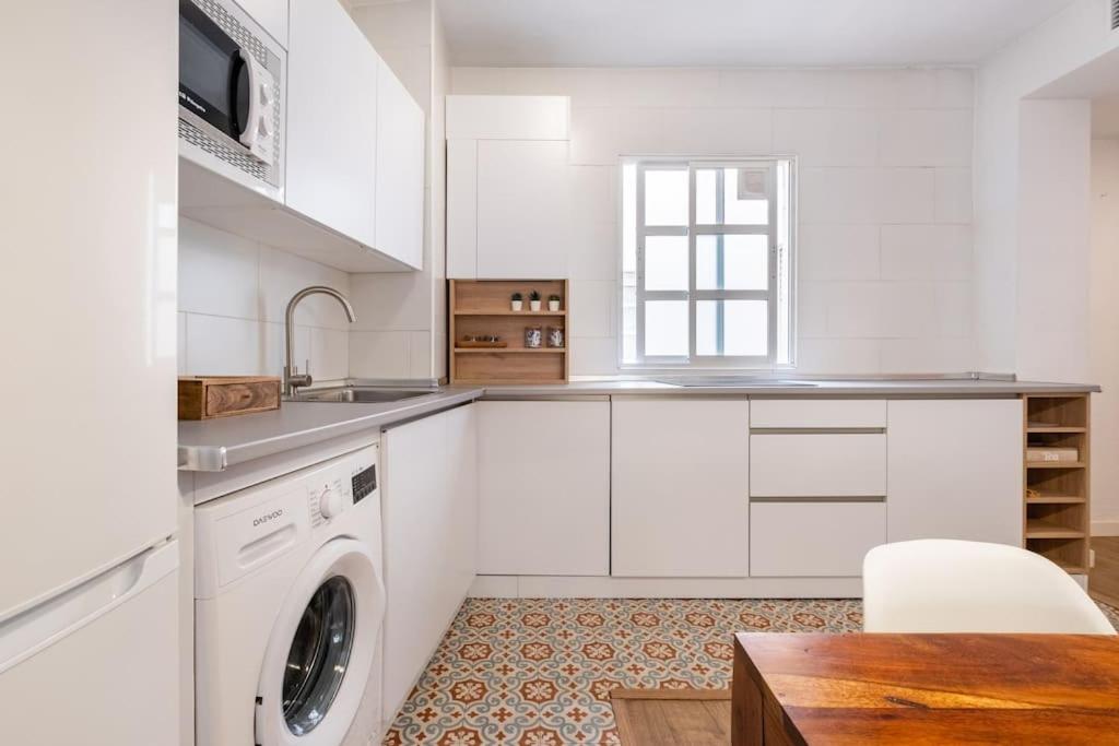 マラガにあるHistorical Center Apartment Malaga parking and smart tvの白いキッチン(洗濯機、テーブル付)