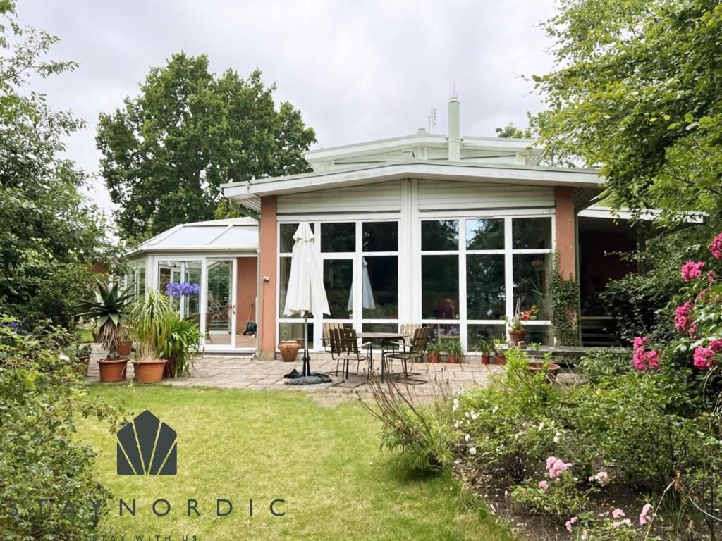 uma casa com um jardim de Inverno com um pátio em Modern villa with sea view in Beddingestrand em Beddinge Strand