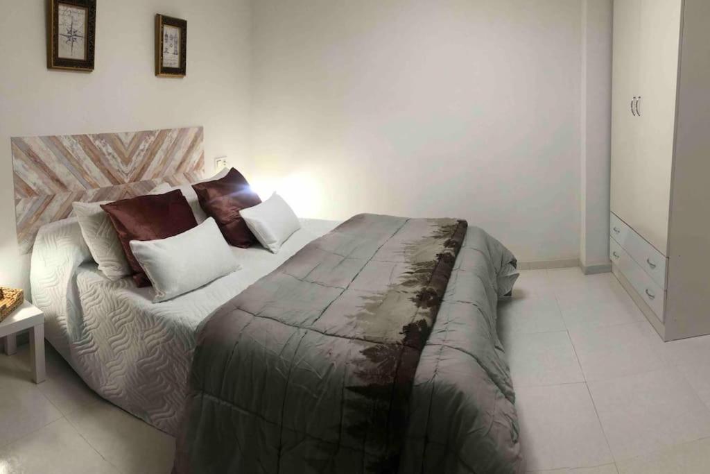 a bedroom with a large bed with pillows on it at Apartamento Andaluz CARMA in Torrox Costa