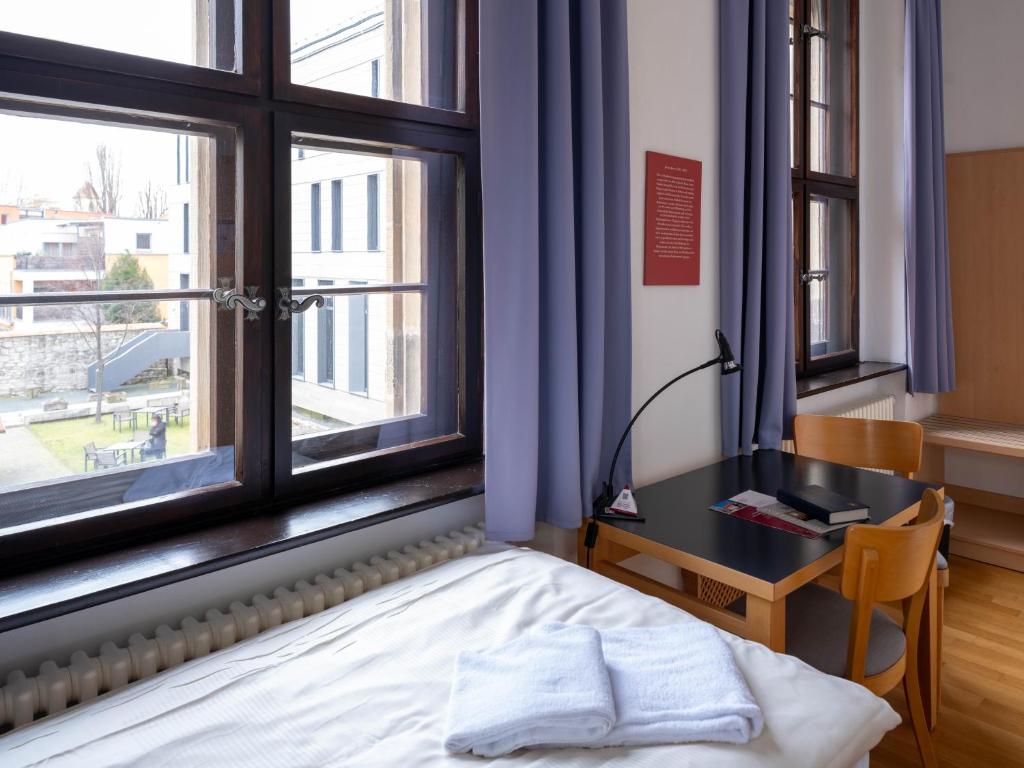 Postel nebo postele na pokoji v ubytování Ev. Augustinerkloster zu Erfurt