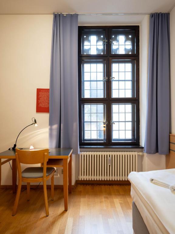 Postel nebo postele na pokoji v ubytování Ev. Augustinerkloster zu Erfurt
