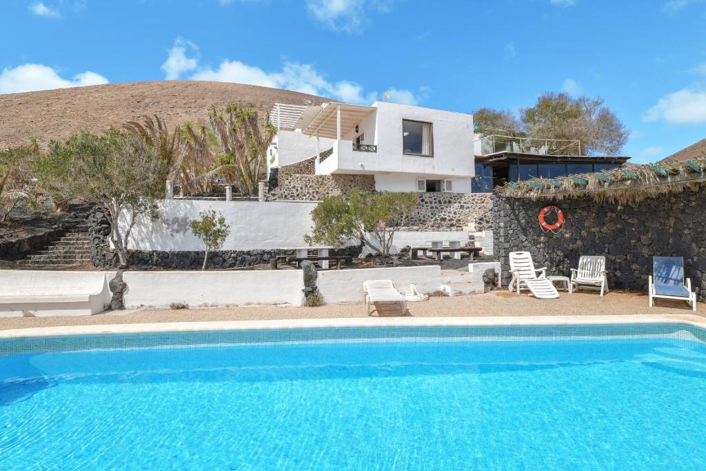 uma villa com uma piscina e uma casa em Finca La Calerita C em Yaiza