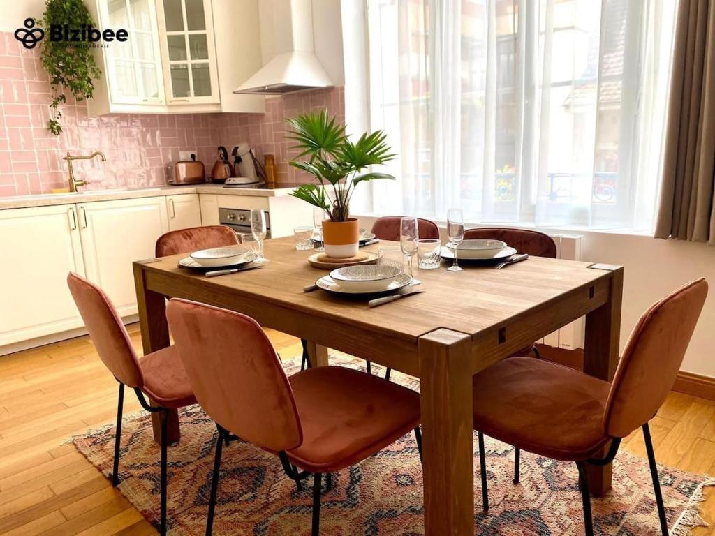 una mesa de madera en una cocina con sillas alrededor en Le Pink Lady Avenue de champagne, en Épernay