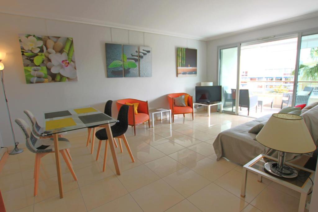 カンヌにあるFully equipped apartment with large terrace lounge areaのリビングルーム(ソファ、テーブル、椅子付)