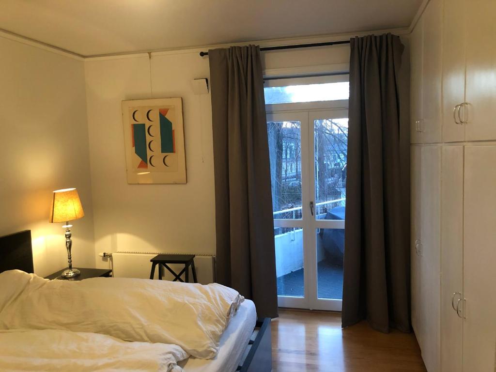 a bedroom with a bed and a sliding glass door at Cosy Apartment in Frogner in Oslo
