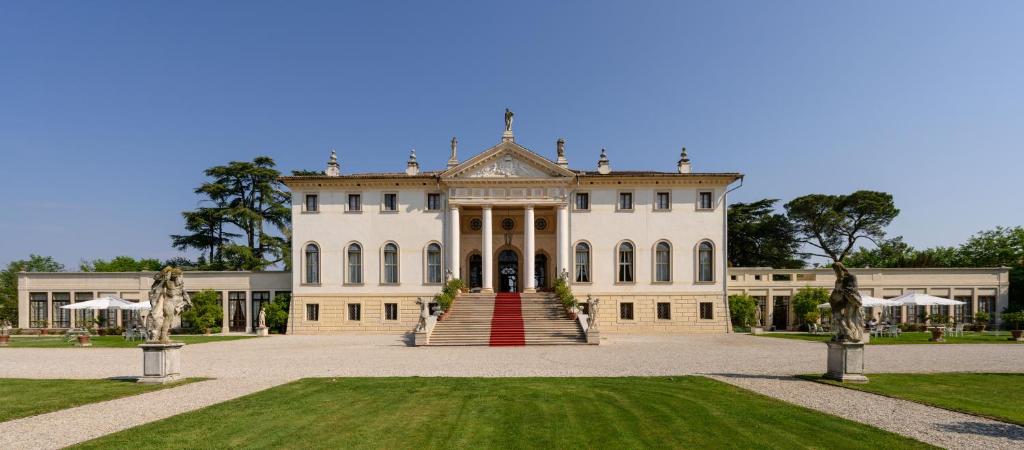 una grande casa bianca con scala rossa di Hotel Villa Cornér Della Regina a Vedelago