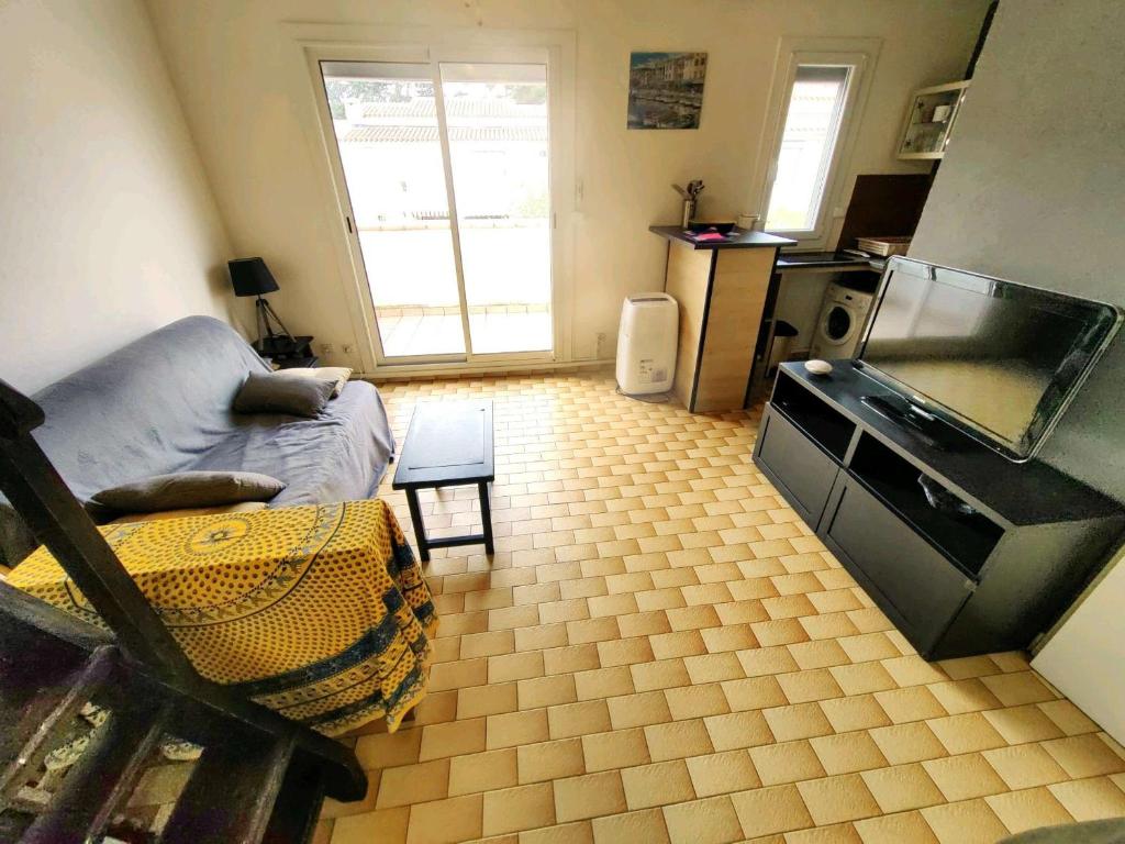 un salon avec une grande télévision à écran plat dans l'établissement Charmant T2 mezzanine, 5 pers, parking sécurisé, Proche Plage & Commerces - FR-1-607-63, au Cap d'Agde