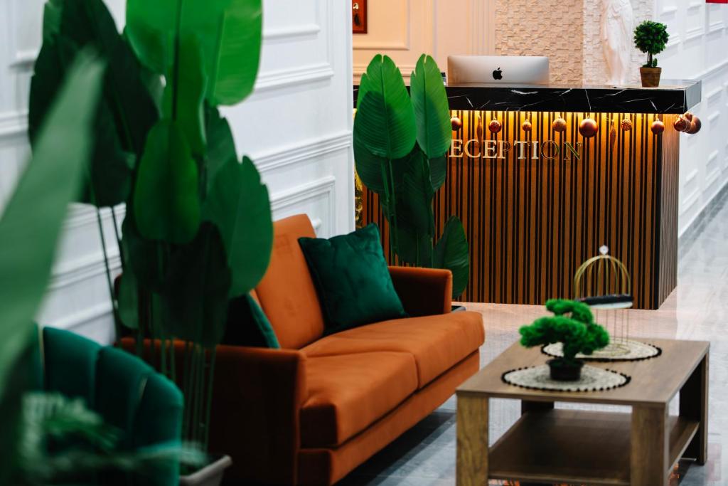 Andor Luxury Hotel في دوريس: غرفة معيشة مع أريكة برتقالية وطاولة