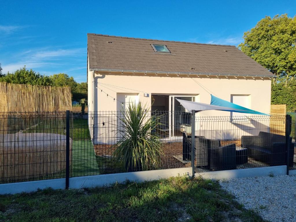 a house with a fence in front of it at Jolie Maison récente, au calme avec jardin et parking gratuit in Saint-Denis-de lʼHôtel