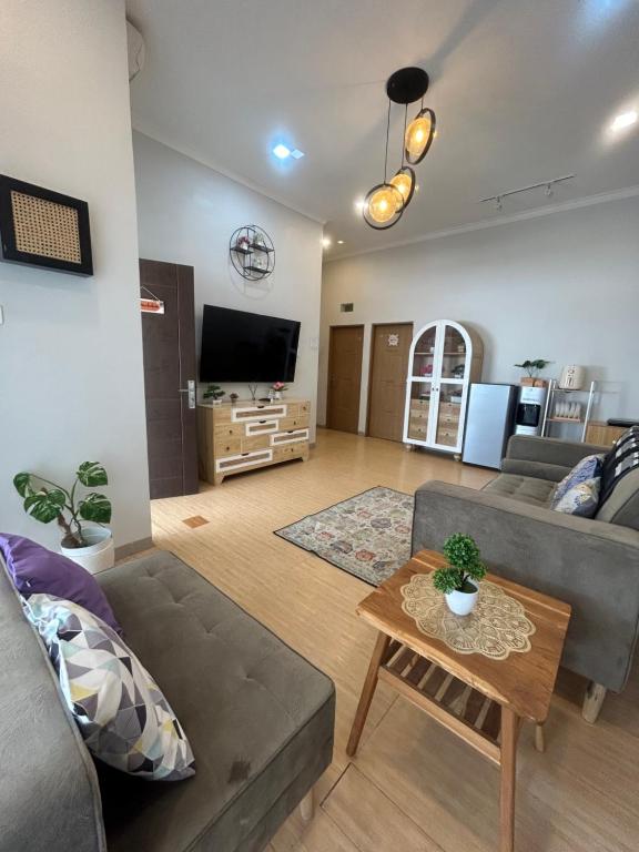 ein Wohnzimmer mit einem Sofa und einem Tisch in der Unterkunft Clamitan House in Padalarang