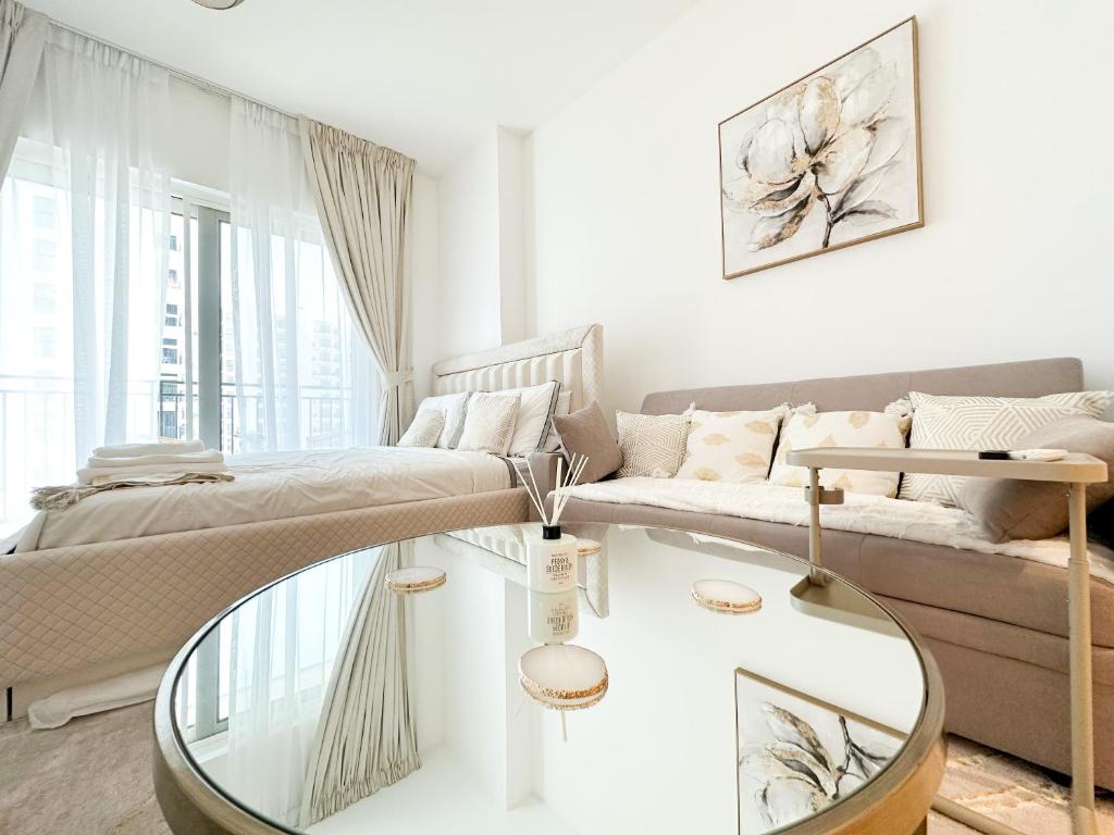 a living room with a couch and a glass table at Canal Front Haven 206WB12 in Abu Dhabi