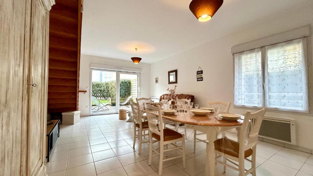 ein Esszimmer mit Tisch und Stühlen in der Unterkunft L'échappée in Fort-Mahon-Plage