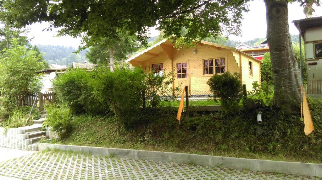 a small yellow house sitting on top of a yard at SwissCottages Blockhaus in Schönengrund