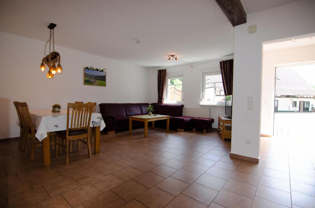 sala de estar con mesa y sofá en Ferienhof Verse Ferienwohnung Kornkammer, en Lennestadt