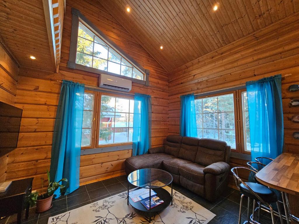 a living room with a couch and a table at Tahko Villa Vaarna in Tahkovuori