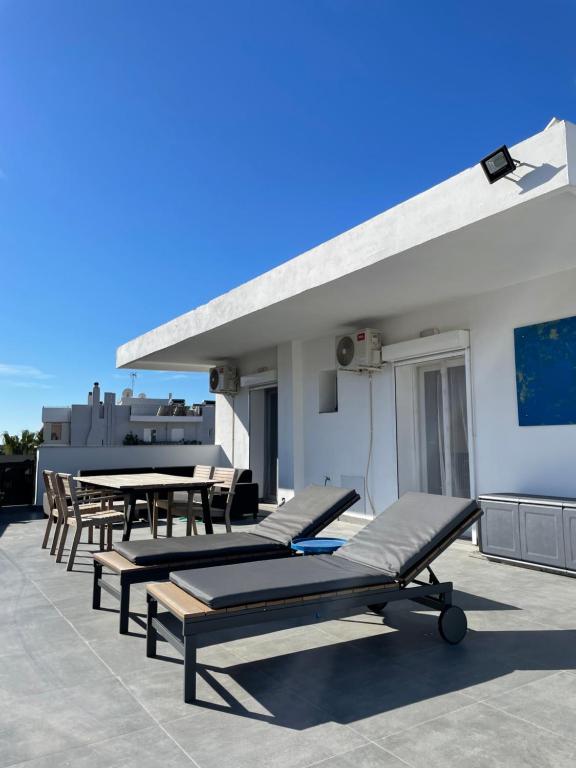 eine Reihe von Liegen und Tischen auf einer Terrasse in der Unterkunft roofgarden apartment close subway station in Athen