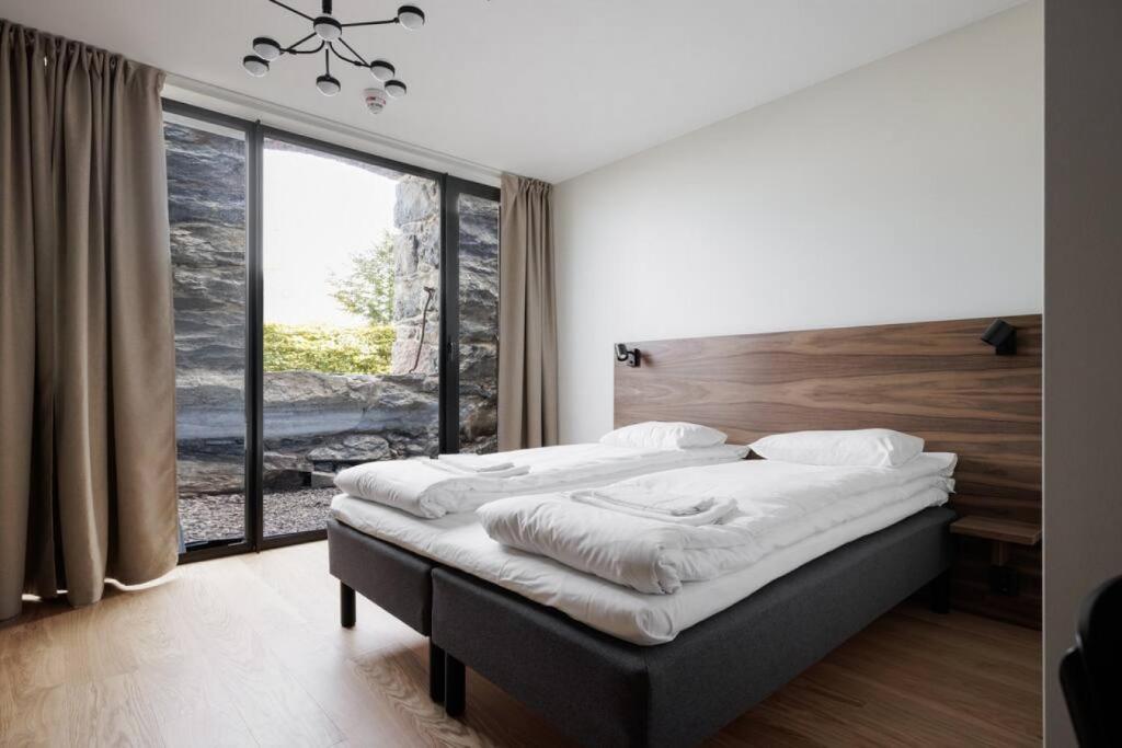 a bedroom with a bed and a large window at Brand new Studios Amidst Ancient Ruins Oasis in Stockholm
