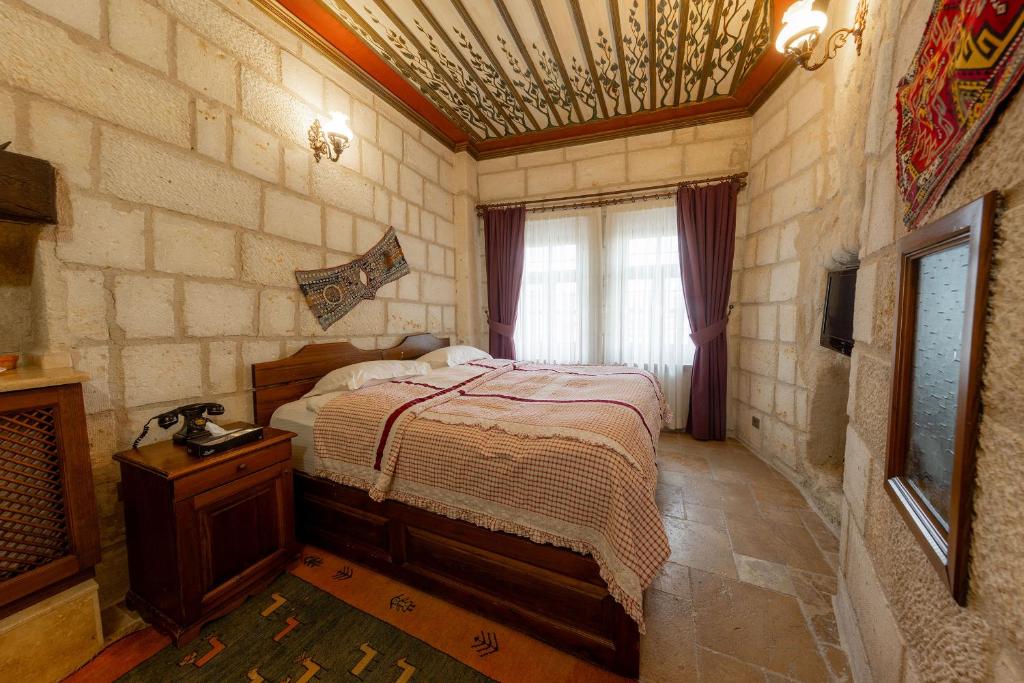 a bedroom with a bed and a tv in a room at Cappadocia Cave Suites Adult Only in Goreme