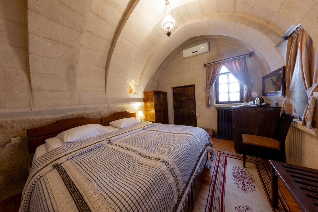 a bedroom with a large bed in a room at Cappadocia Cave Suites Adult Only in Goreme
