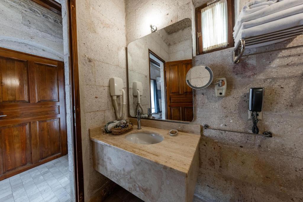 a bathroom with a sink and a mirror at Cappadocia Cave Suites Adult Only in Goreme