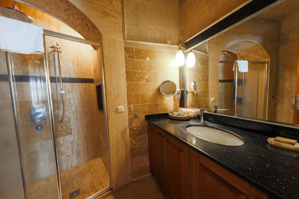 a bathroom with a sink and a shower at Cappadocia Cave Suites Adult Only in Goreme