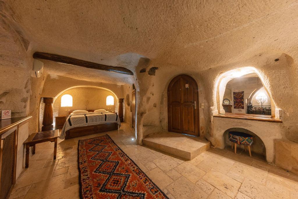 a large bedroom with a bed and a fireplace at Cappadocia Cave Suites Adult Only in Goreme