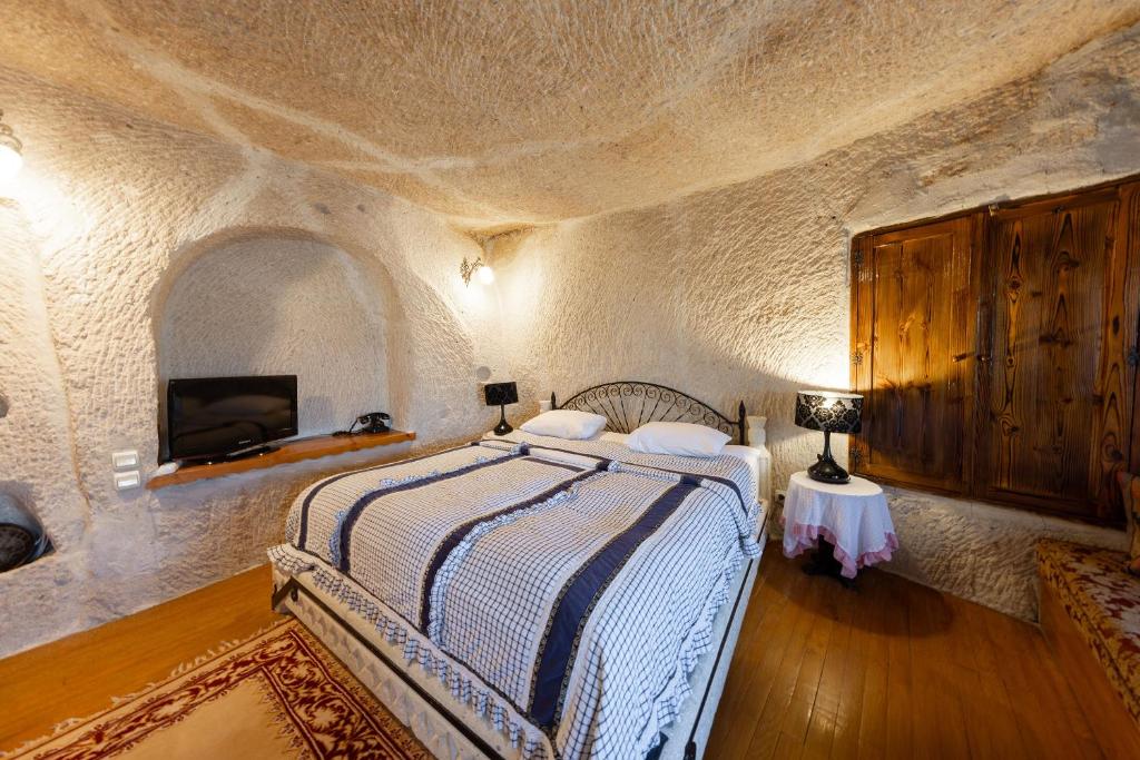 a bedroom with a bed in a stone room at Cappadocia Cave Suites Adult Only in Goreme