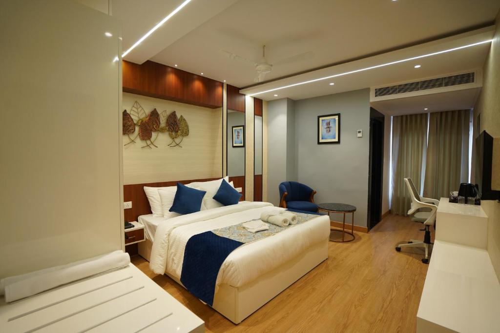 ein Hotelzimmer mit einem Bett und einem Schreibtisch in der Unterkunft Hotel The Landmark Chhatarpur in Chhatarpur