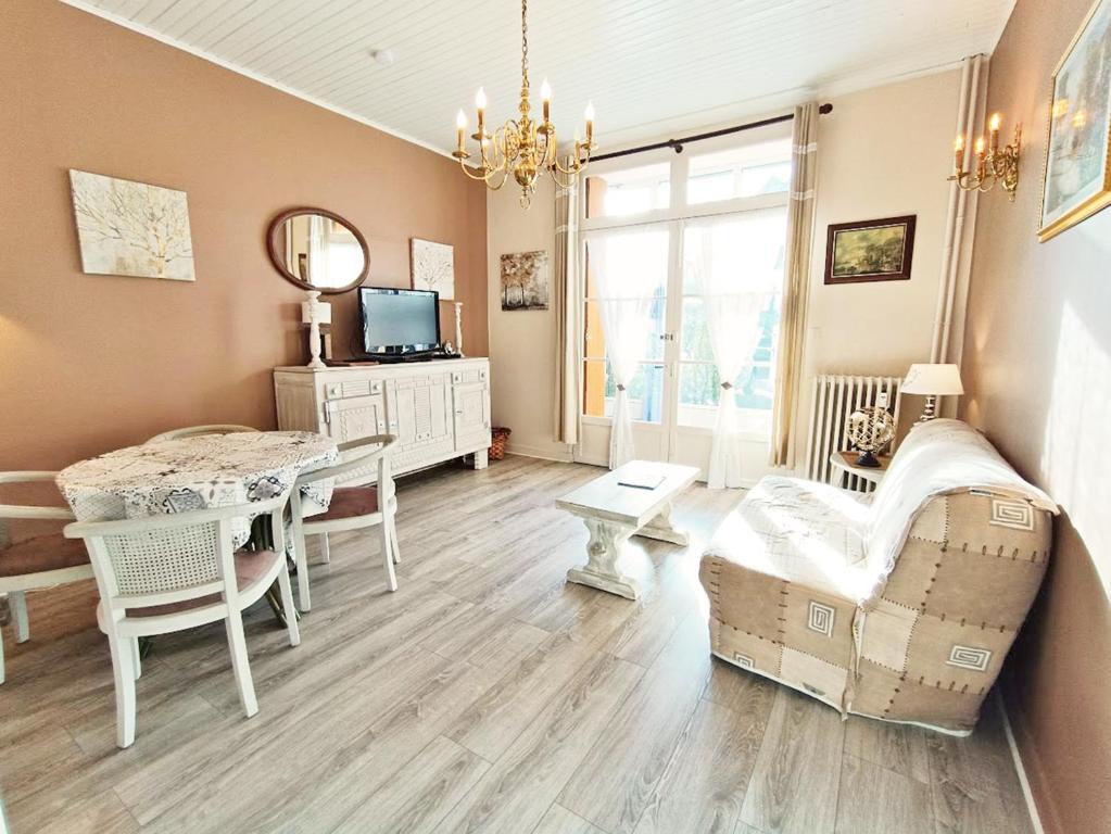 un salon avec une table et une salle à manger dans l'établissement Le Petit Paradis, T3, wifi, parking, véranda, à Luchon