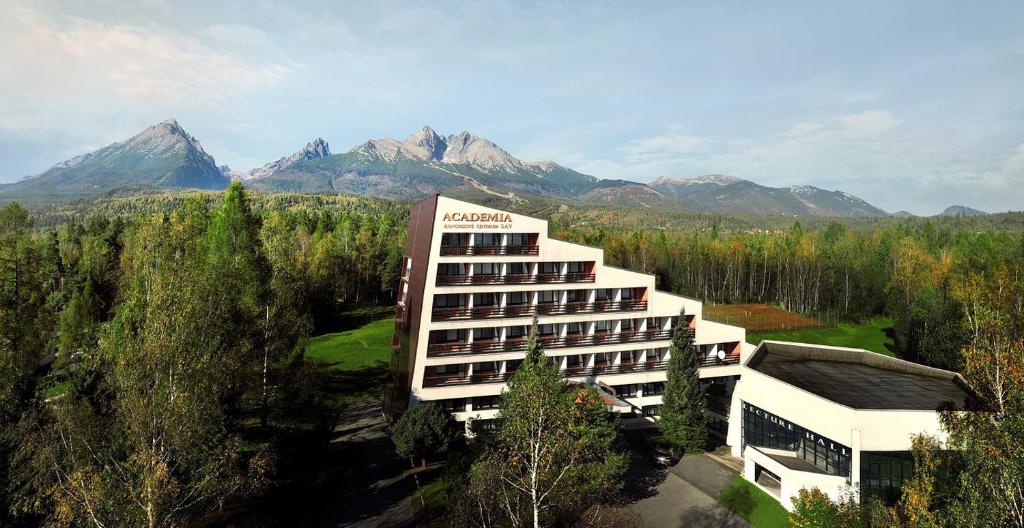 un edificio de hotel con montañas en el fondo en Hotel Academia en Stará Lesná