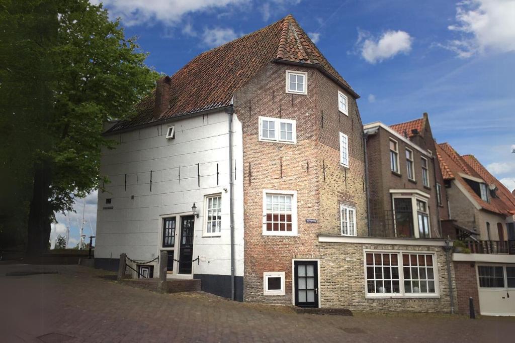 un vecchio edificio in mattoni e bianco con tetto marrone di Torenhuis Medemblik a Medemblik