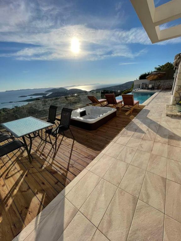 a patio with a table and chairs and a bath tub at Villa Buddha in Syvota