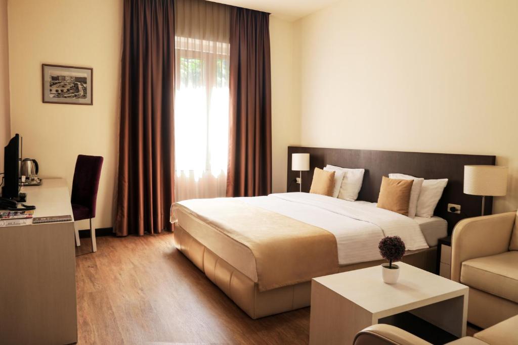 Habitación de hotel con cama y sala de estar. en My Hotel Yerevan, en Ereván