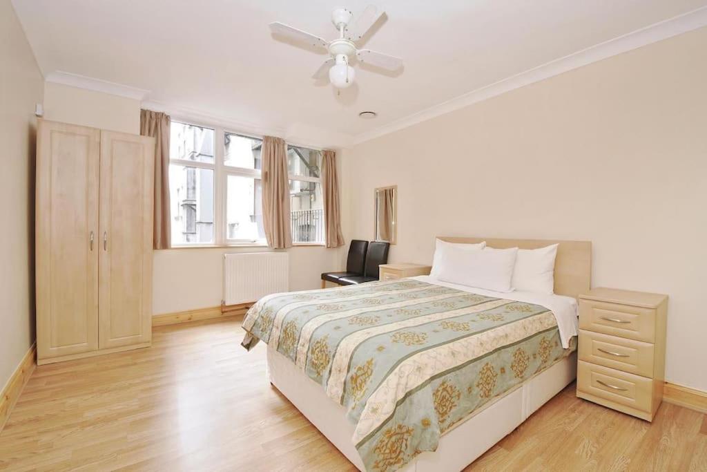 1 bedroom apartment in Leicester Square في لندن: غرفة نوم بسرير ومروحة سقف